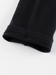 Gros plan du poignet de T-shirt noir en coton avec détails de couture soignés