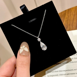 Elegant silver necklace with a sparkling teardrop zircon pendant on a black gift card