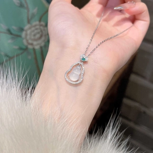 Silver-toned gourd pendant necklace with a white gemstone and pave diamond accents