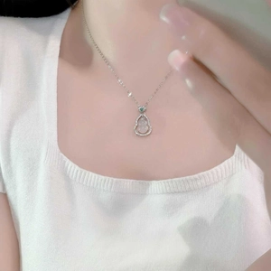 Detail of a gourd jadeite pendant with micro-inlaid diamonds on a silver chain