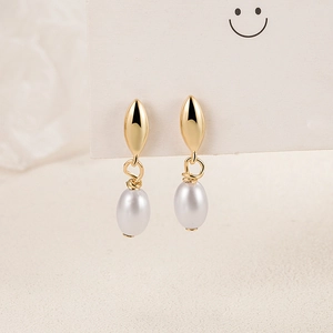 Elegant gold leaf studs with teardrop pearls shown on a minimalist display card