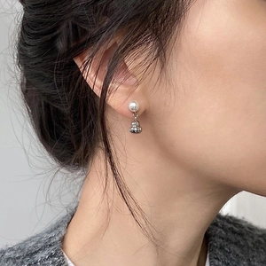 Detail view of pearl and silver gourd drop earring worn on model for a modern oriental look