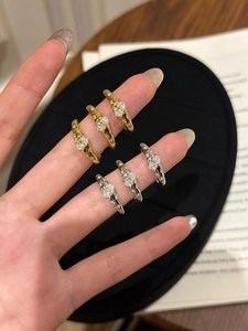 Detail of stacked oval moissanite rings in gold and silver finish on a finger