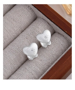 Detail of matte brushed heart earrings with starburst engraving and centered zircon