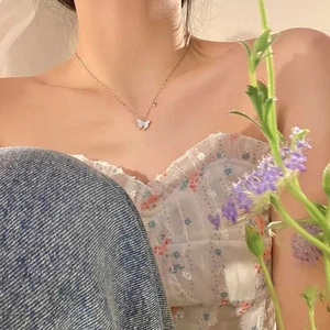 Close-up of elegant gold butterfly necklace with sparkling crystals worn by a model