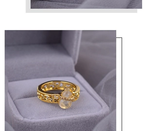 Detail of gold hollow ring with jade gourd in a purple velvet jewelry box