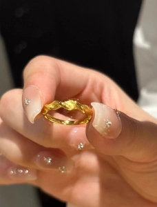 Detail of golden Mobius ring showing twisted texture with matte and polished finishes