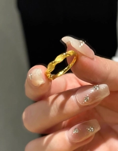 Macro shot of twisted gold ring featuring a brushed texture finish and intricate details
