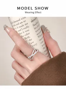Close-up of a three-layer criss-cross ring with diamonds worn on a finger