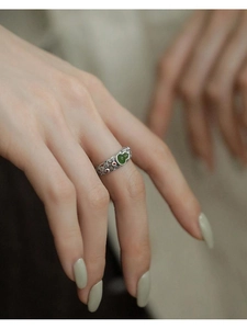 Detail of vintage Hetian jade gourd ring with hollow cloud patterns on silver band