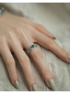 Detail of vintage silver hollow carved ring with green jade gourd and enamel flowers