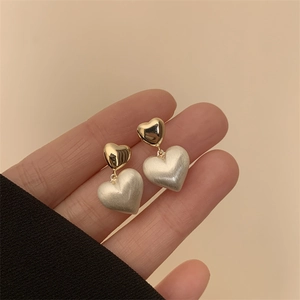 French luxury heart-shaped earrings with brushed matte finish and gold metallic texture