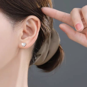 Minimalist brushed metal heart stud earring worn on model for a refined look