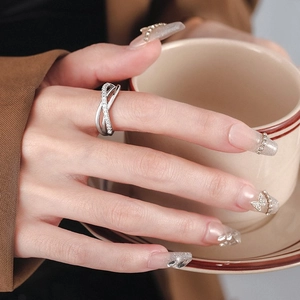 Chic silver triple layer crisscross ring with pavé diamonds on index finger