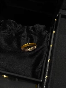 Nahaufnahme eines Vintage Goldrings mit Stern und Zirkonia auf schwarzem Samtbeutel
