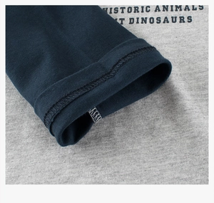 Macro shot of cotton sleeve cuffs with double-needle stitching and dinosaur typography