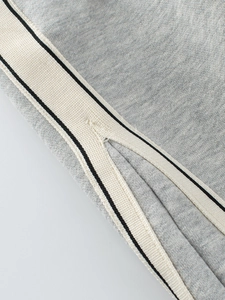 Kids grey loose knit sweatpants featuring white striped side tape and V-split hem detail