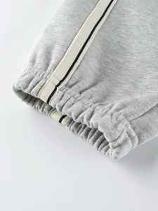 Kids grey cotton sweatpants featuring ribbed cuffs and striped side tape detailing