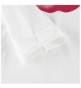 Detail der Doppelnaht am Ärmelbündchen des weißen Baumwoll-Langarmshirts mit rotem Druck
