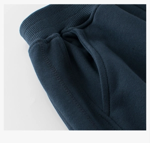 Detail of navy cotton sports pants featuring a wide elastic waistband and side pockets