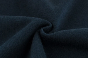 Close-up of deep blue high-quality knit fabric texture with soft cotton blend folds