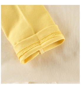 Detailed macro view showing the hem stitching and yellow cotton knit texture of the sleeve