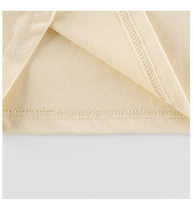 Detailed close-up of double-needle stitching and soft knit texture on beige kids' t-shirt