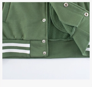 Detail of green fleece kids jacket with metal snaps and striped ribbed hemline