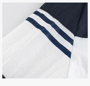Detail of color-block navy and white windbreaker with parallel decorative stripes