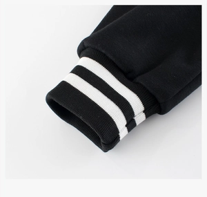 Detail of black ribbed cuffs with white stripes on a high-quality cotton fleece jacket