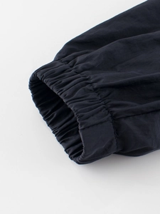 Close-up of elastic cuffs on a black lightweight nylon hooded jacket for children