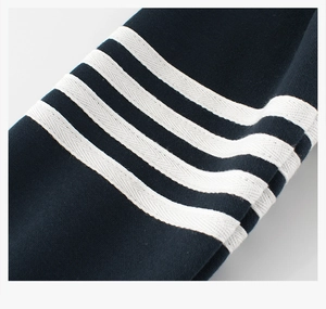 Détail de la manche en coton bleu marine avec quatre rayures blanches et tissage sergé