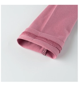 Close-up of pink long-sleeve cuff with purple stitching and fine fabric texture