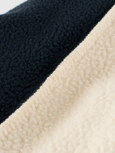 Détail de la couture en polaire marine et crème sur un ensemble d'hiver pour garçons