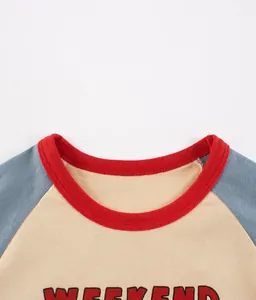 Detail eines Kinder-Raglan-Shirts mit rotem Rippenausschnitt und WEEKEND-Aufdruck
