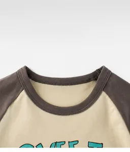 Close-up of the grey ribbed neckline and raglan shoulder detail on a cotton toddler t-shirt