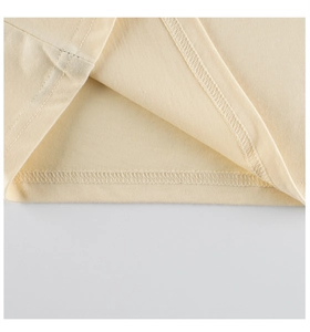 Detail view of double-needle stitching on the hem of a yellow cotton toddler t-shirt