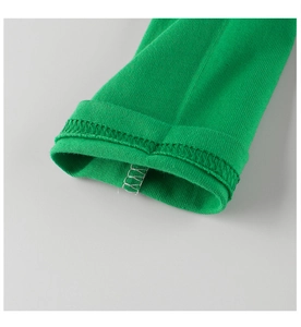 Detail of green ribbed knit cuffs with precise double-needle stitching on cotton fabric
