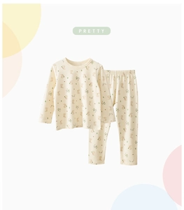 Vista detallada del conjunto de pijama infantil beige con estampado de conejo y flores
