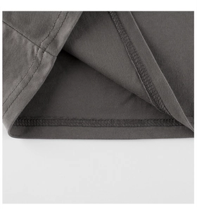 Close-up of double-stitched hem and fine cotton texture on dark gray girl's t-shirt