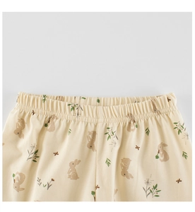 Detalle de cintura elástica en pantalones beige para niños con estampado de conejos y flores