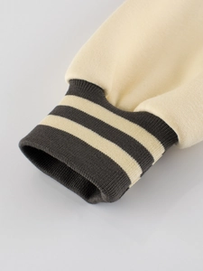 Kids baseball jacket with cream knitted fabric and striped ribbed cuffs closeup view