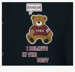 Detail of fleece sweatshirt with a bear print and SUNBEAM slogan on navy fabric