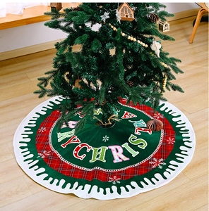 Close-up of Merry Christmas tree skirt featuring red green plaid and wavy white edges