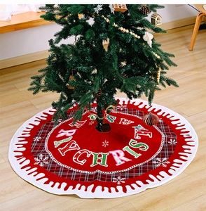 Detail of red Christmas tree skirt with Merry Christmas text and snowflake edges
