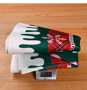 Detailed view of red and green snowflake tree skirt being weighed on a scale