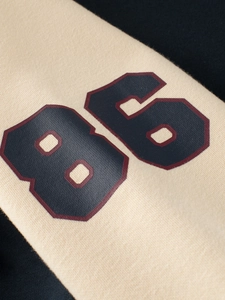 Kids baseball jacket in beige and navy blue patchwork with number 86 printed on the chest