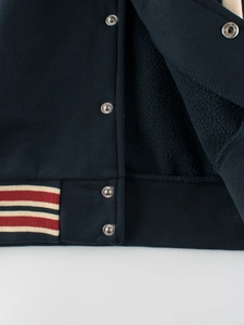 Fleece-lined kids baseball jacket in navy blue with striped elastic hem and metal snaps