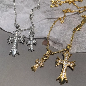 Detail of gold and silver gothic cross pendants with sparkling pavé-set stones