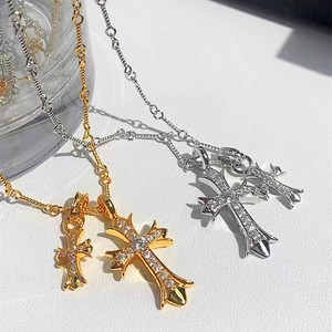Close-up of gold and silver Gothic cross necklaces with sparkling pavé crystal details